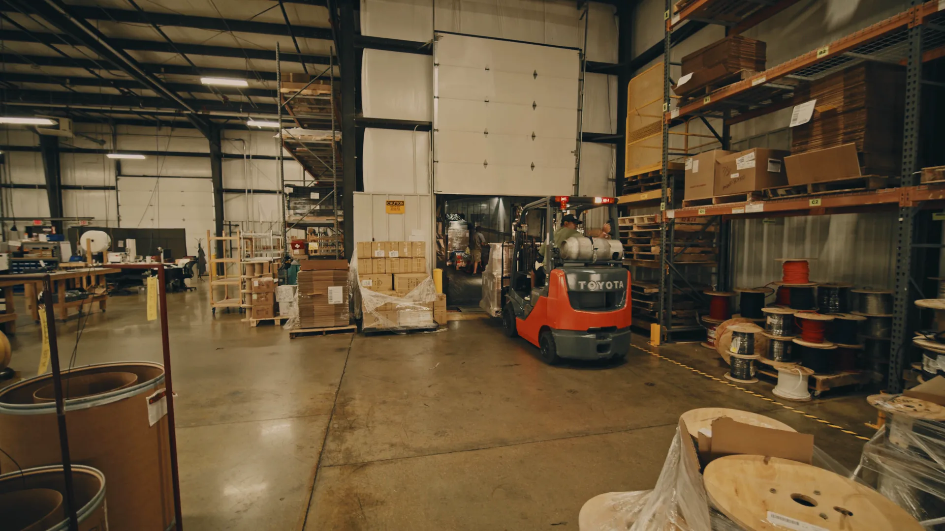 A warehouse dock door, stock footage, in which a forklift brings a wrapped pallet in from the dock, boxed, with its path, the dock line, the inbound count and the stall drawn over it